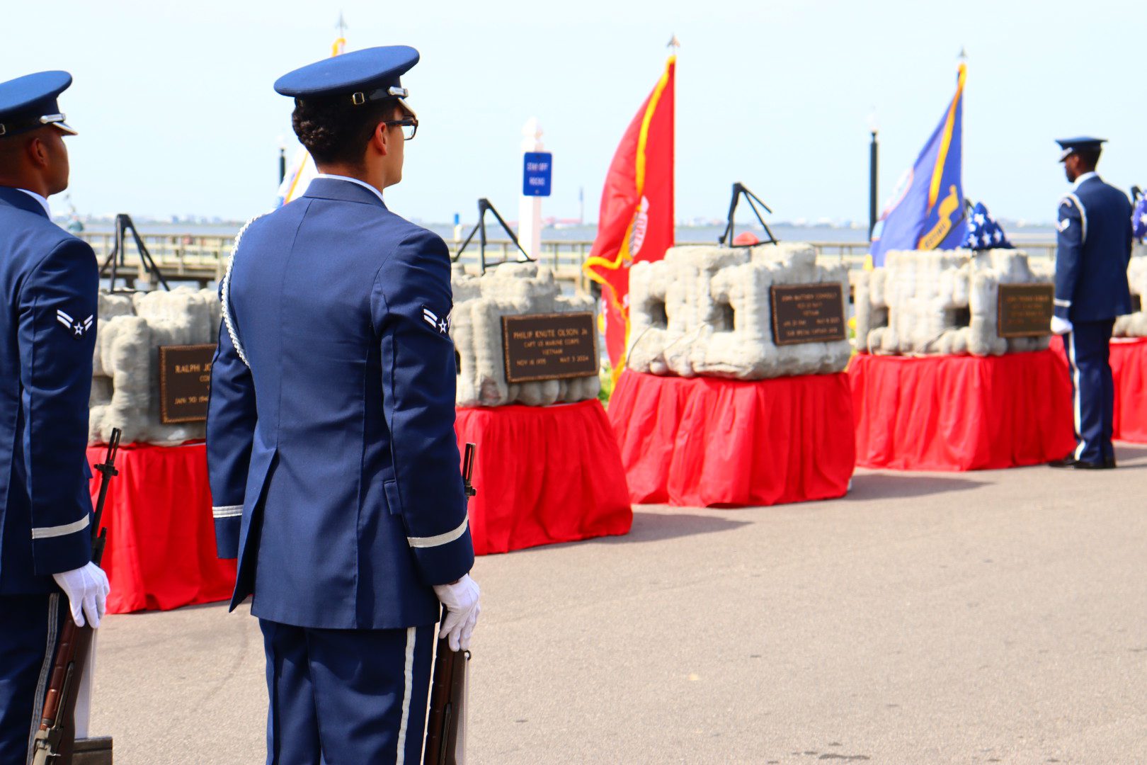 Uniformed service members holding an American flag at a Veterans Memorial Reef ceremony